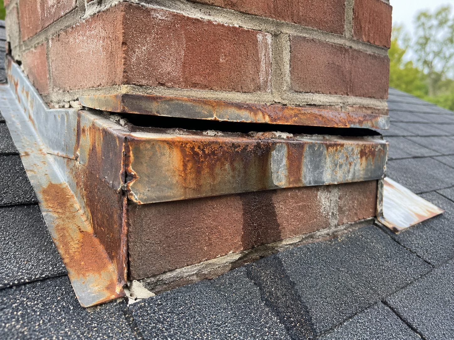 Rusty chimney flashing with visible water gap