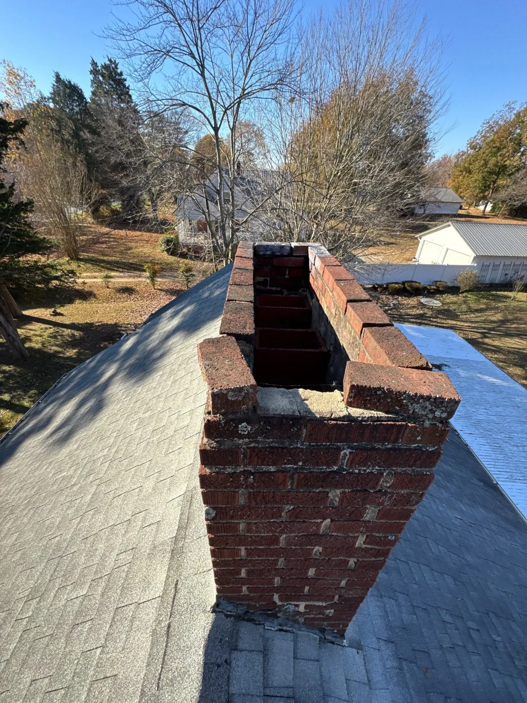 Brick chimney and shingles checked during a roof inspection in Archdale, NC