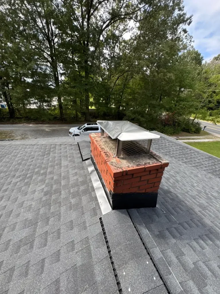 New shingle roof around a brick chimney on a Greensboro, NC home after roof replacement
