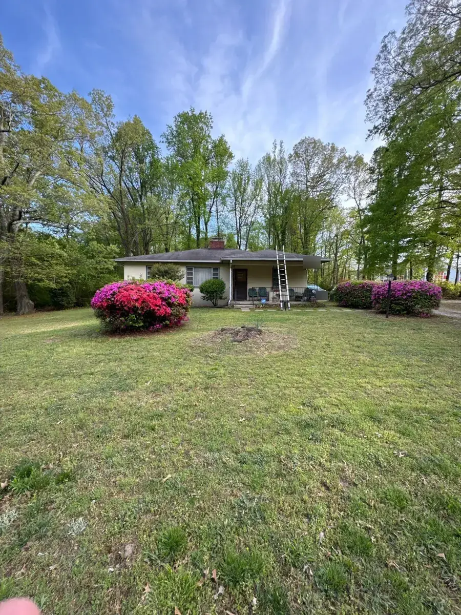 Brick ranch home with azaleas on West Vandalia Road in Greensboro, NC before roof replacement