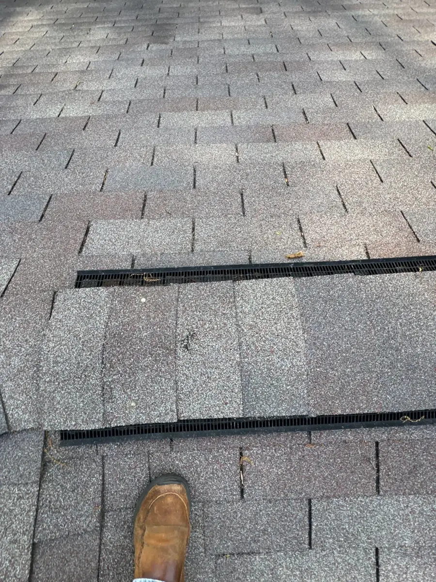 Close-up of old shingles and a roof vent on a Greensboro, NC home before replacement