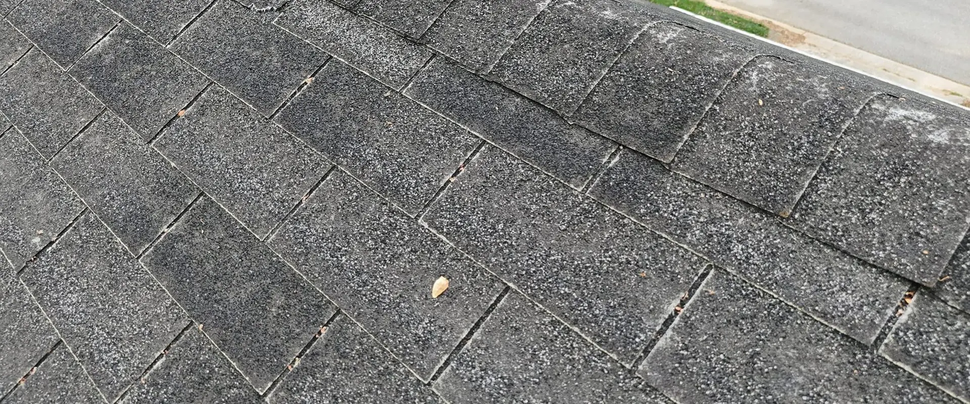 Close-up photo documenting damaged shingles on a Greensboro, NC roof