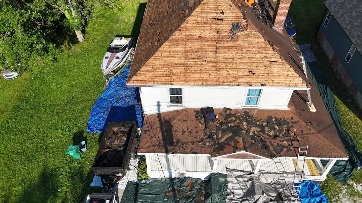 Aerial view of a storm-damaged roof being torn off down to the decking in High Point, NC