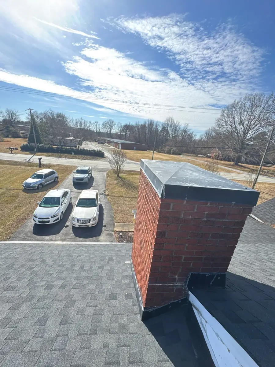 Brick chimney and shingle roof on a Kernersville, NC home before replacement