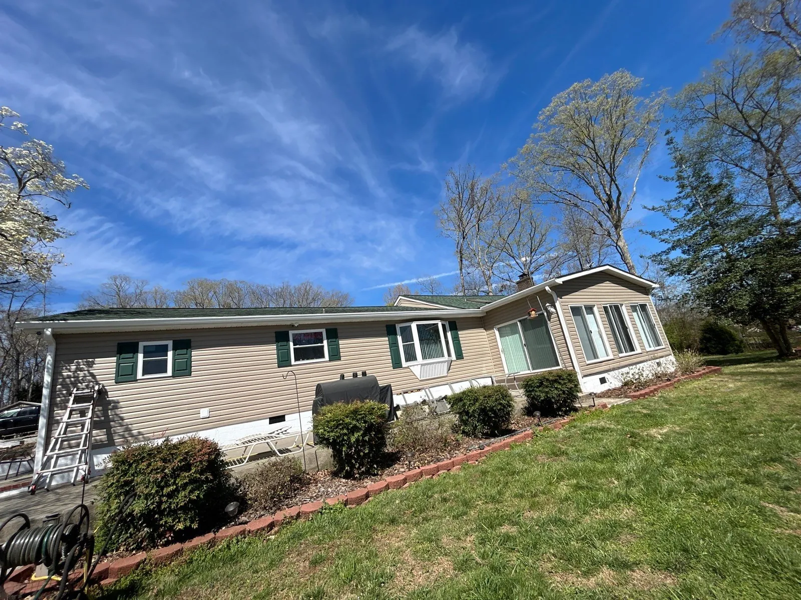 Lexington, NC home with new white seamless gutters and a new green shingle roof