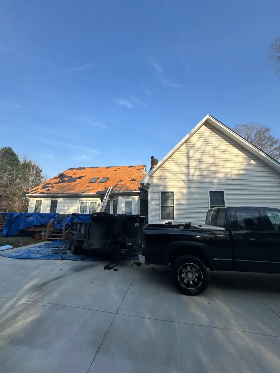 Roof tear-off in progress on a Cape Cod style home in Lexington, NC