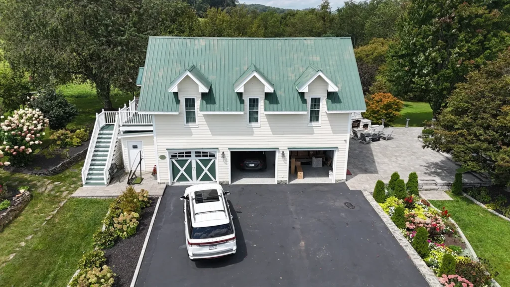 Drone view of a Sparta, NC carriage house with an old green ribbed metal roof
