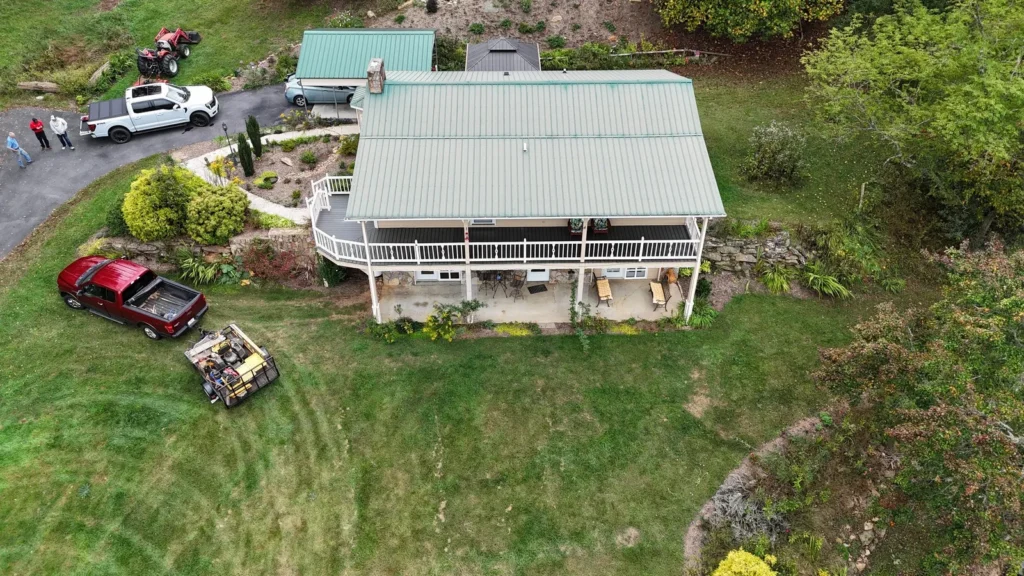 Drone view of the second Sparta, NC house with its old green ribbed metal roof