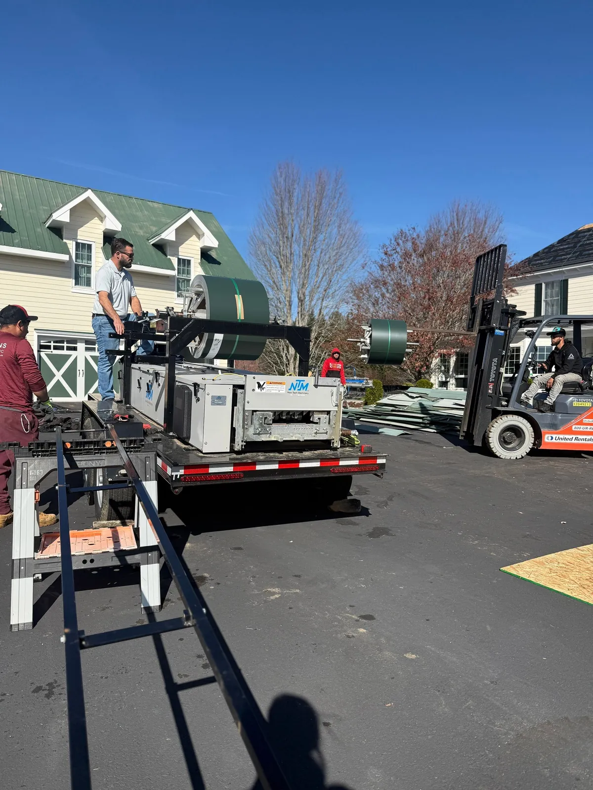 Statewide Roofing standing seam roll former running custom metal roof panels on site in Sparta, NC