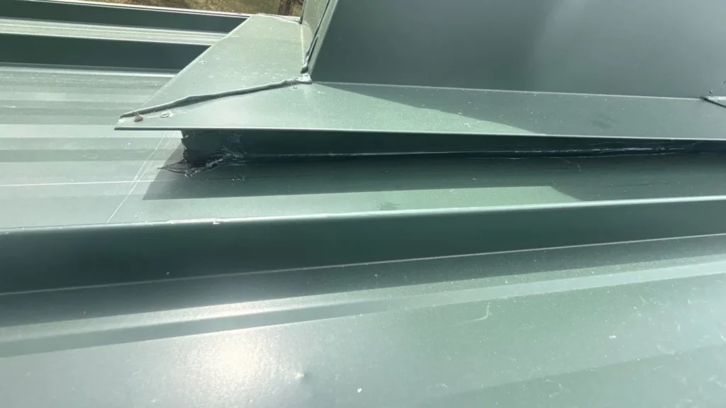 Z-bar closure trim detail on a green standing seam metal roof