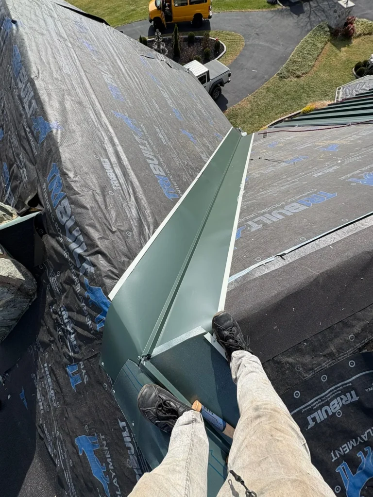Hand-made valley metal being installed on a standing seam metal roof in Sparta, NC