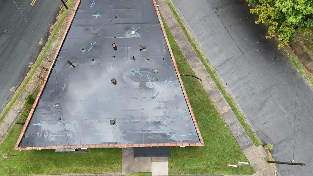 Drone view of the old black membrane on a church flat roof in Winston-Salem, NC before replacement