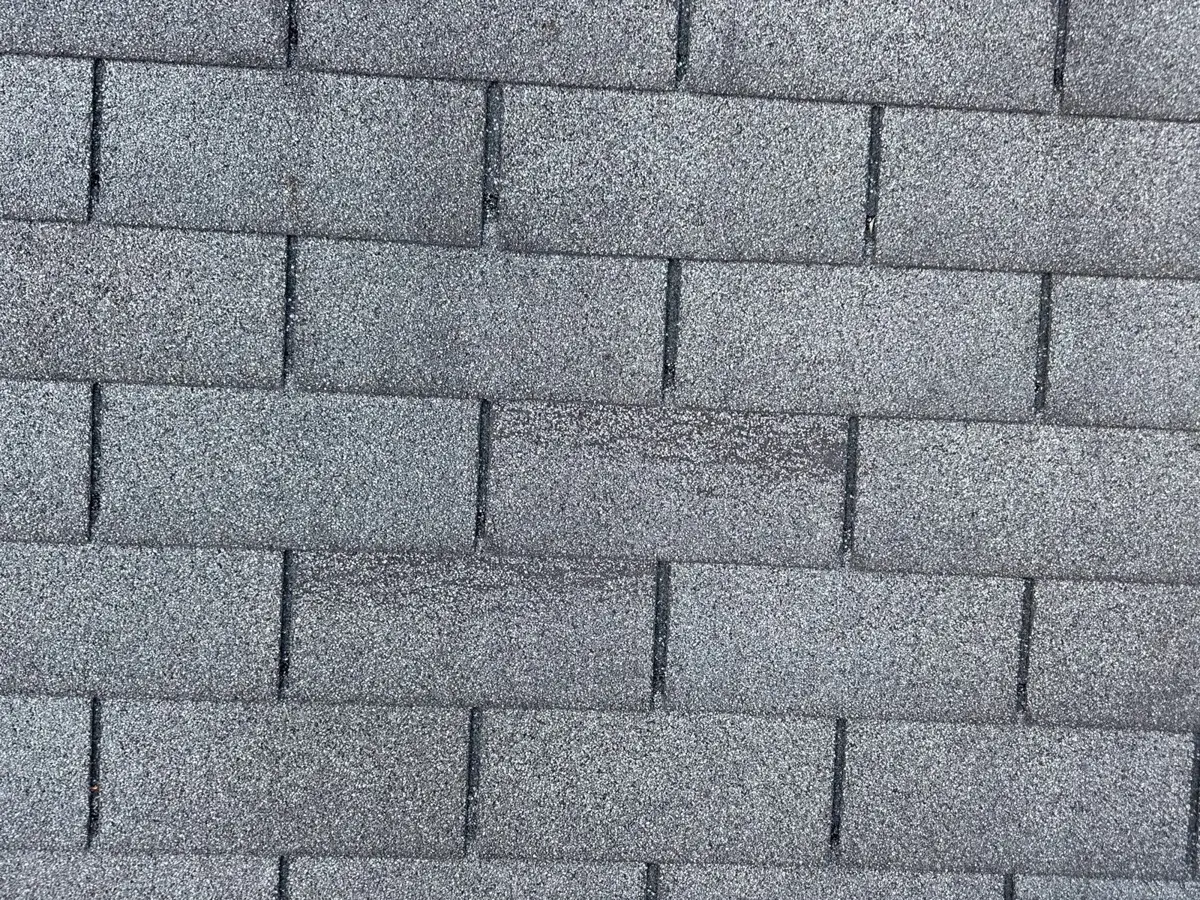 Close-up of worn, aging asphalt shingles before a roof replacement